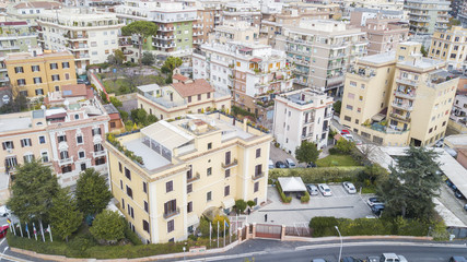 Fototapeta premium Vista aerea di una parte della citta di Roma. Tanti palazzi sono presenti tra le vie della città con qualche albero piantato nelle piazze e nei viali.
