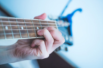 Junge Frau spielt Gitarre, Westerngitarre, Gitarrenhals und Kapodaster