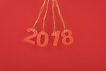 close up view of 2018 year sign hanging on strings isolated on red