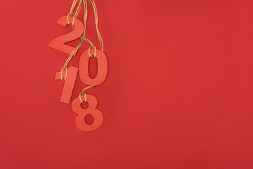 close up view of 2018 year sign hanging on strings isolated on red