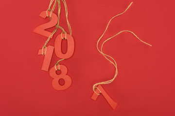 close up view of 2018 year sign hanging on strings isolated on red