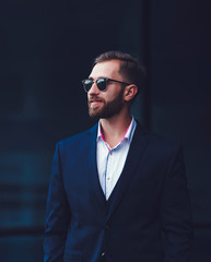 Handsome businessman posing in suit and sunglasses