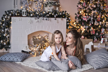 My daughter and her mother lying on the pillows around the Christmas tr