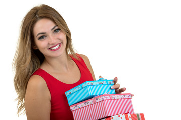 Portrait of a smiling pretty girl holding stack of gift boxes isolated over white background