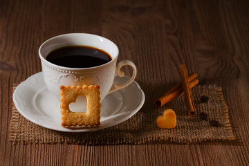 cookie like heart and a cup of coffee on wooden table