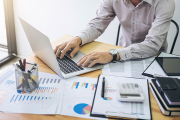 Image of business strategy, businessman working with laptop, tablet and financial document data graph on table in office