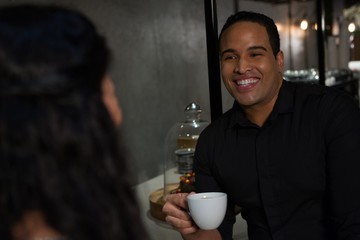 Happy man interacting with woman while having coffee