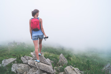 Naklejka na ściany i meble girl traveler with a camera in mountains