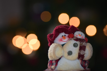 Cute snowman doll mother and child with blurry bokeh light background