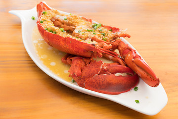 Red baked lobster with herbs on the background of a wooden table