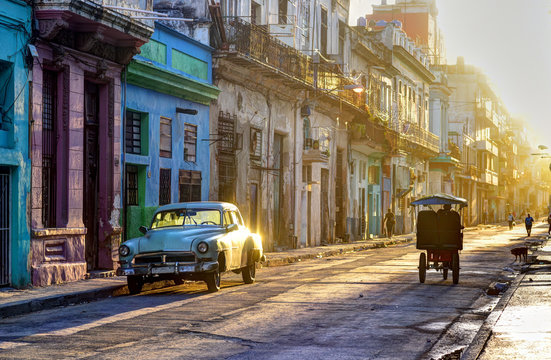 Street scene in Old Havana (La Habana Vieja), classic car, bicitaxi and people going to work, Cuba
