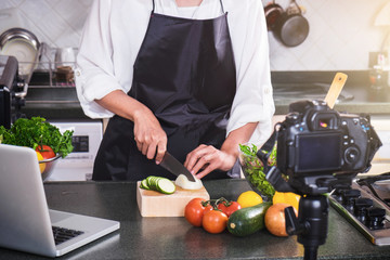 recording of making cook, woman hand cutting onion on chopping wood board with sharp knife and cooking vegetables salad in kitchen
