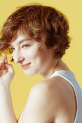 Obraz premium Beautiful and emotional girl on a yellow background without make-up and with natural skin