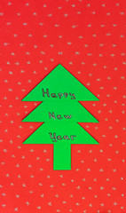Happy New Year text on green Christmas tree on red background with asterisks