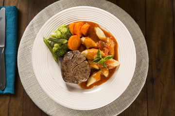Delicious healthy food with grilled meat, gnocchi potato, red sauce and broccoli on the plate. View from the top.