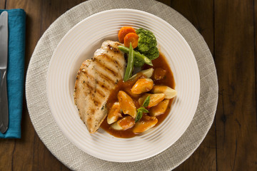 Delicious healthy food with grilled chicken, gnocchi potato, red sauce and vegetables on the plate. View from the top.