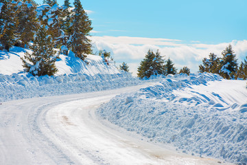 Empty snow covered road in winter landscape