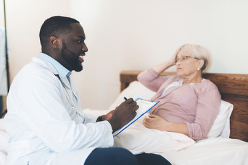 The doctor examines an elderly patient in a nursing home.