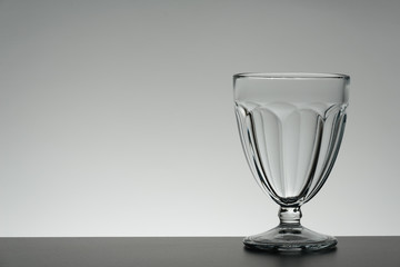 Crystal glass illuminated on mirror and black background