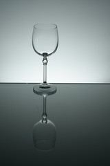 Crystal glass illuminated on mirror and black background
