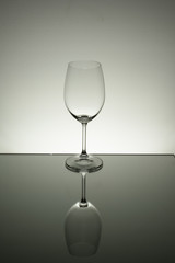 Crystal glass illuminated on mirror and black background