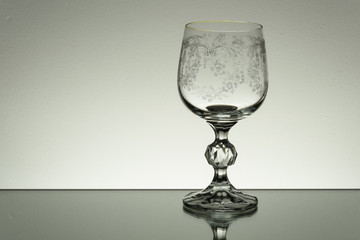 Crystal glass illuminated on mirror and black background
