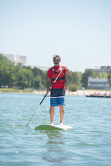 man enjoying a ride on the lake with paddleboard