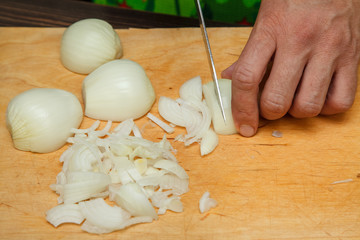 Fototapeta na wymiar Food preparation - cutting onions with knife