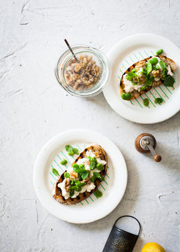 Overhead view of broad beans served with toast on a plate