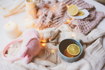 Cozy winter morning at home. Hot tea with lemon, knitted sweaters and modern interior details. Flat lay still life composition.
