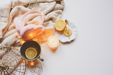 Cozy winter morning at home. Hot tea with lemon, knitted sweaters and modern interior details. Flat lay still life composition.