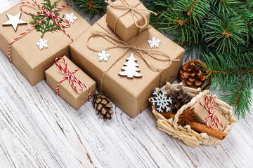 Christmas gift boxes and fir tree branch with basket on wooden table