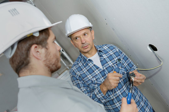 two builders working with electricity indoors