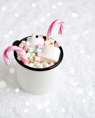 Cup with Hot Chocolate, Marshmallows, Candy Canes on the Snow