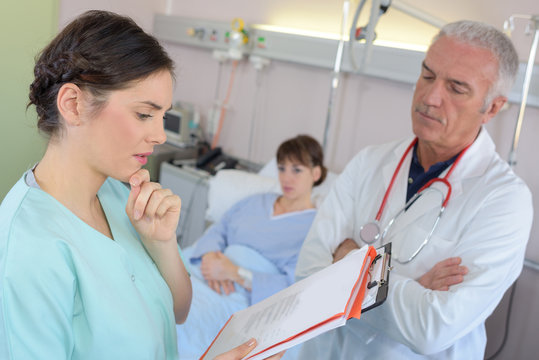 male doctor discussing some medical records with nurse