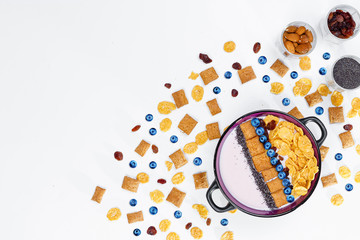 Breakfast, bowl with homemade yogurt and cornflakes and fresh blueberries on white background, top view, flat lay. Concept of healthy food, healthy food, detox. Copy Space