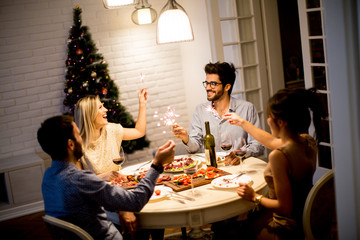 Young people celebrating New Year and drinking red wine