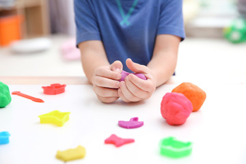 Little boy engaged in playdough modeling at daycare