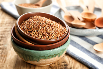 Bowls with raw buckwheat on table