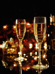 Two glasses of champagne over blur spots lights background. Celebration concept, free space for text