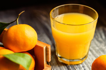 Glass of fresh juice and mandarins on table