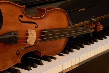 Fototapeta na wymiar Geige Ausschnitt auf Klavier Tasten