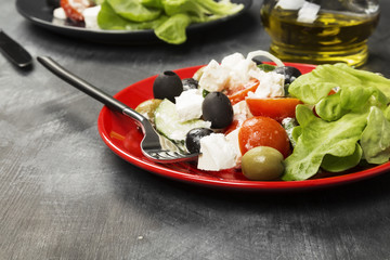 Greek salad feta, cherry tomatoes, olives, cucumbers on a dark background