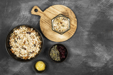 Granola with honey, nuts, fruit on a dark background. Top view, copy space. Food background