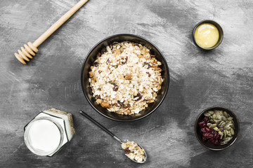 Granola with yogurt, honey, nuts, fruit on a dark background. Top view. Food background
