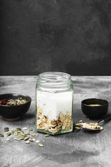 Granola with yogurt, honey, nuts, fruit on a dark background