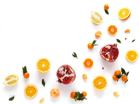 Composition from orange, pomegranate, mandarins with leaves isolated on white background. Food pattern of fruits. Creative flat layout of fruit slices, top view.
