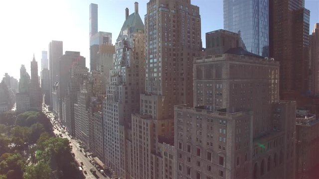 Aerial real time shot, camera is flying above Central Park, approaching to the corner of West 95th Street and Fifth Avenue in New York. Camera is slowly moving left side.
