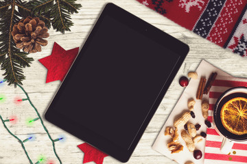 Tablet on a wooden table, christmas scene