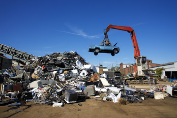 recycle cars  and trucks being tossed to to scrap heap